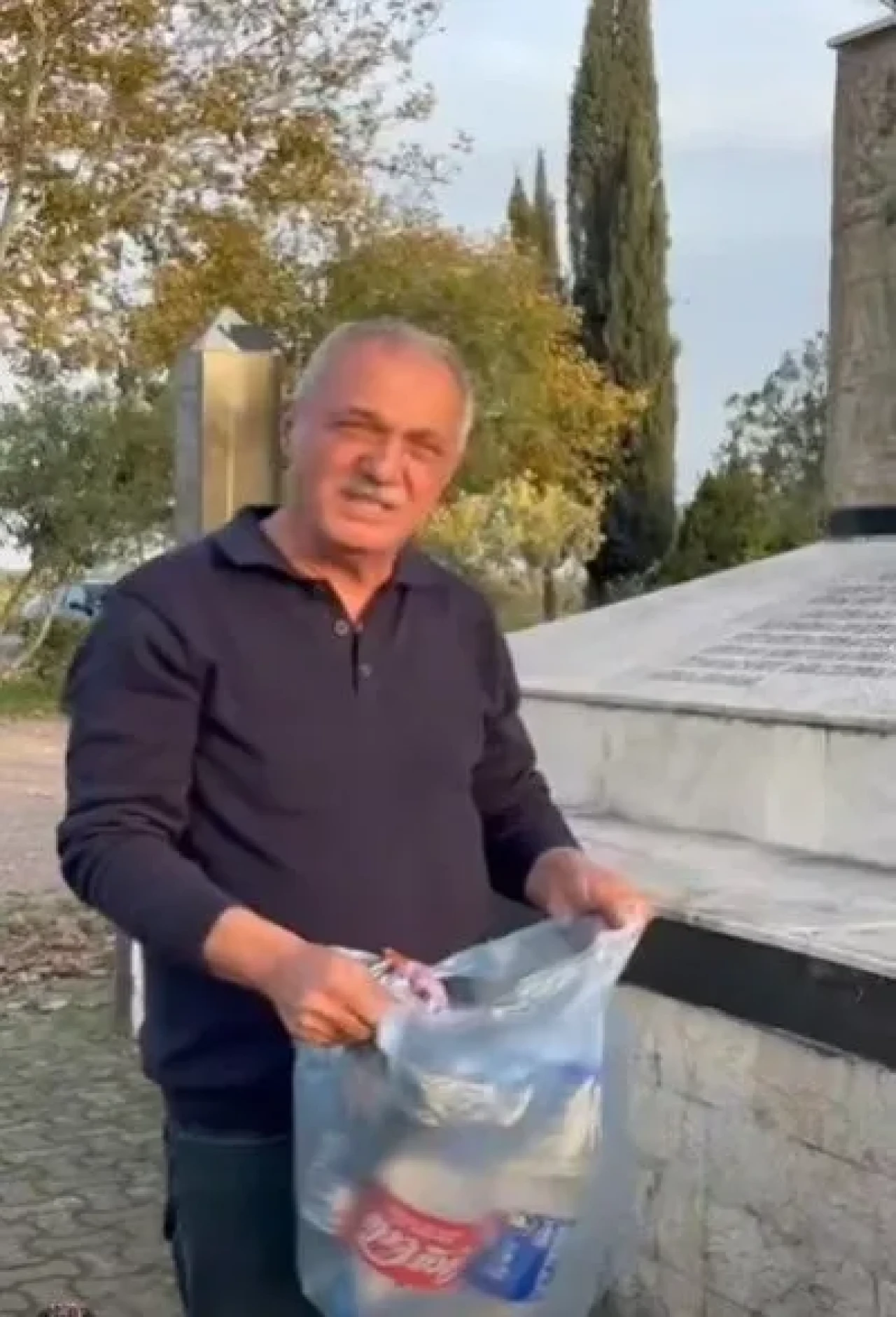 Sultanhisar Belediye Başkanı Osman Yıldırımkaya şehitliğe saygısızlık yapanlara çöpleri toplayarak tepki gösterdi