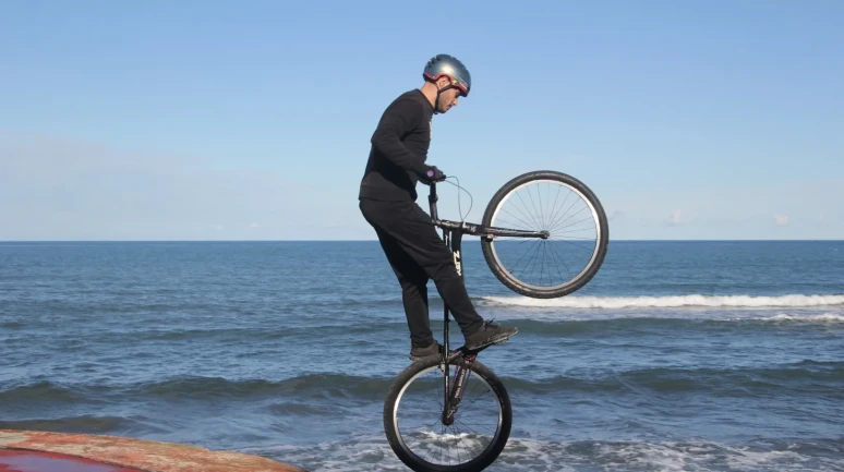 Ordu'da bisiklet tutkunu genç sahildeki kayalıklarda nefes kesen gösteri yaptı
